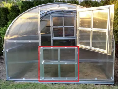 A greenhouse with a red-highlighted window section.