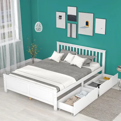 A white wooden bed frame with drawers is shown in a bedroom setting with teal walls and artwork.