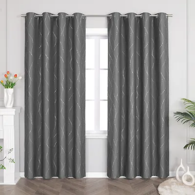 Two dark gray curtains with silver wavy stripes hang on a curtain rod in front of a window. A white fireplace mantel with a vase of flowers is visible to the left, and a plant is visible to the right.