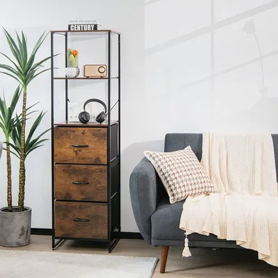A tall storage cabinet with three drawers and three shelves is placed next to a sofa with a throw blanket and a pillow.