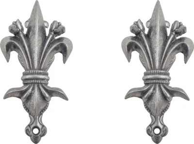 A pair of silver fleur-de-lis decorative accents.