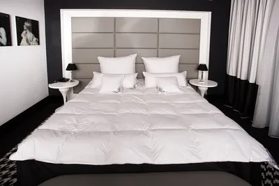 A neatly made bed with white bedding in a modern bedroom setting.