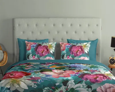 A bed with a duvet cover and pillows featuring a floral pattern.