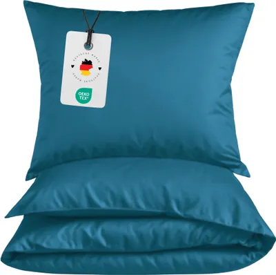 A stack of teal pillowcases with a tag attached to the top one.