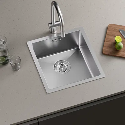 A stainless steel kitchen sink with a faucet is shown on a countertop.