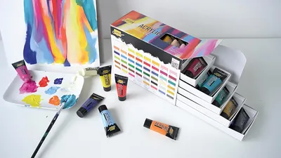 A set of acrylic paints and a palette with paint on it, along with a paintbrush and a canvas with abstract art.