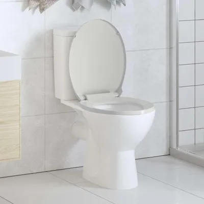 A white toilet with the lid up, set against a tiled wall.