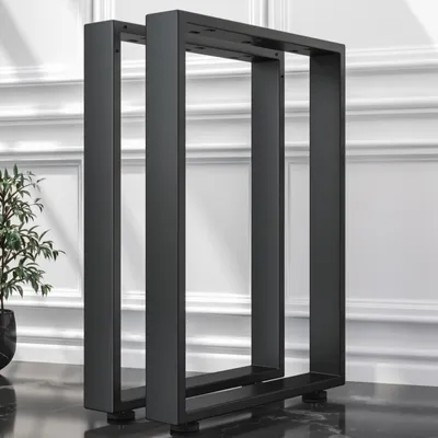 Two black metal table legs are shown standing on a dark floor in front of a white paneled wall.