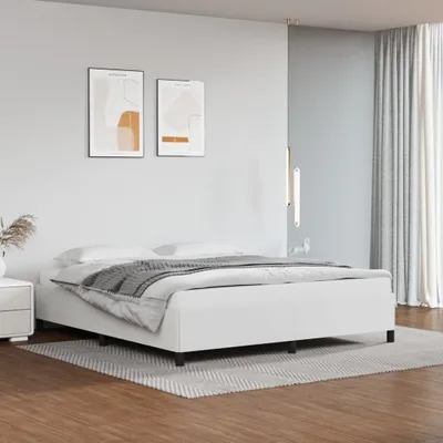 A minimalist bedroom with a white bed frame and abstract art on the wall.