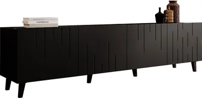 A long, black TV cabinet with a textured front and four doors, placed on a white background. Decorative items are placed on top of the cabinet.