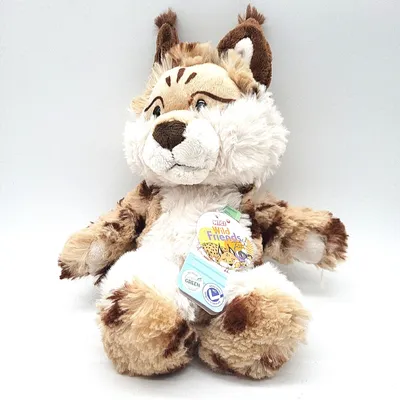 A plush toy lynx sits against a white background, with a tag attached to its chest.