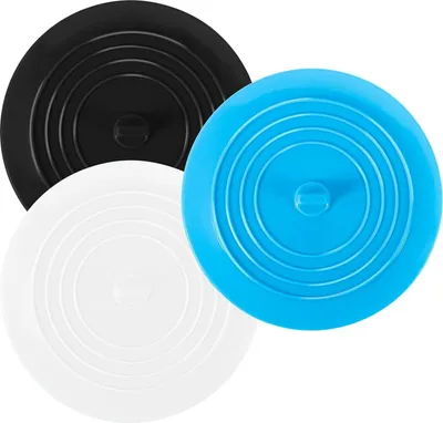 Three silicone drain stoppers in black, white, and blue are arranged in a cluster on a white background.