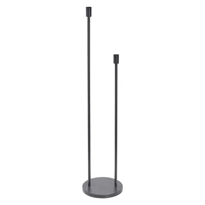 A minimalist floor lamp with two thin stems of different heights, standing on a circular base.