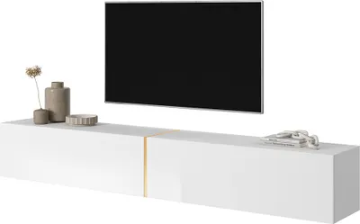 A white TV stand with a gold accent, a television mounted above it, and decorative items on top of the stand.