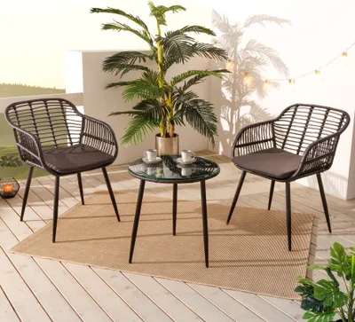 A balcony set with two chairs and a table, decorated with a plant and string lights.