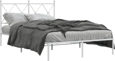 A white metal bed frame with bedding.