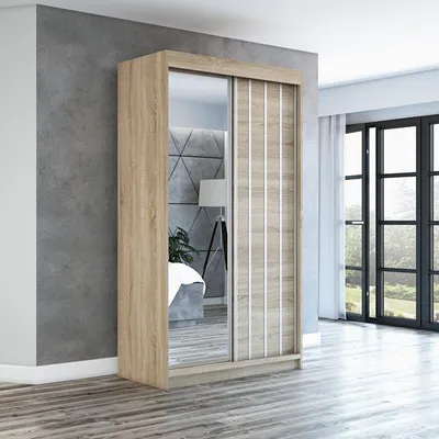A modern sliding door wardrobe with a mirrored door and a wood-effect door with vertical silver accents, set against a textured gray wall and a wooden floor. Large windows with curtains are visible in the background.