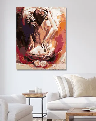 A painting of a person in a fetal position is displayed on a wall above a sofa and armchair.