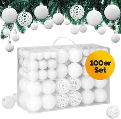 A set of white Christmas ornaments in a clear plastic bag, with some ornaments hanging from a Christmas tree branch.