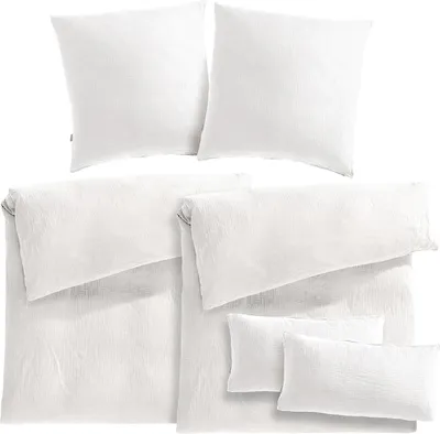 A neatly arranged set of white bedding, including pillowcases and duvet covers, displayed on a white background.