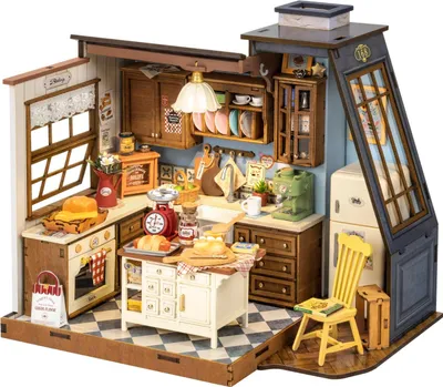 A miniature dollhouse kitchen scene with various accessories and furniture, including a stove, refrigerator, island, and cabinets.