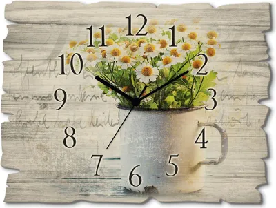 A wall clock with a floral design of daisies in a pitcher, set against a rustic wooden background with handwritten script.