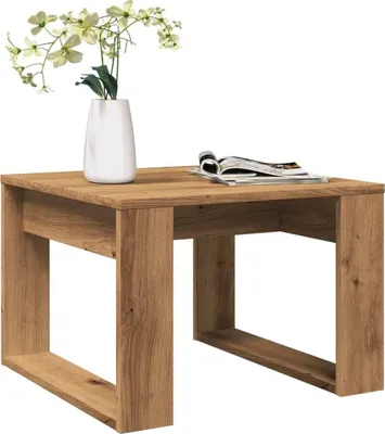 A wooden coffee table with a vase of flowers and a magazine.