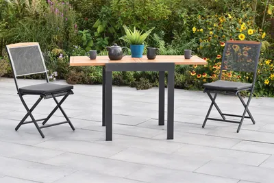 A patio set with two chairs and a table in a garden setting.