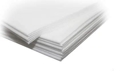 A stack of white disposable bed sheets.