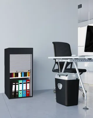 An office scene with a filing cabinet and a desk with a chair and shredder.