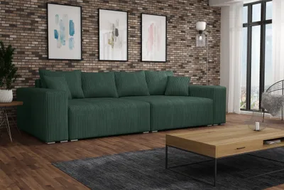 A spacious living room with a large green sofa, coffee table, and artwork on the wall.