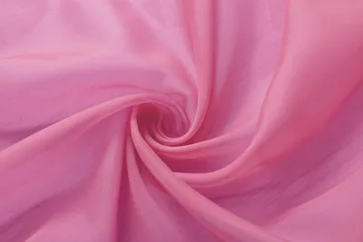 A close-up of pink fabric, folded into a swirl.