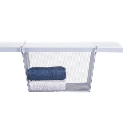 A wire mesh basket hangs beneath a white shelf, holding two folded towels.