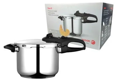 A stainless steel pressure cooker is shown in front of its packaging.
