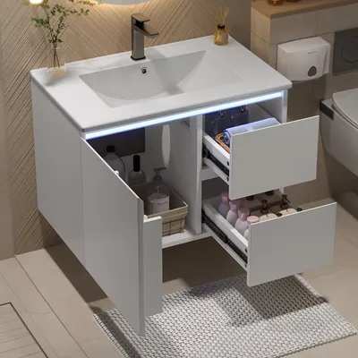 A modern white bathroom vanity with a sink and drawers, featuring internal LED lighting.