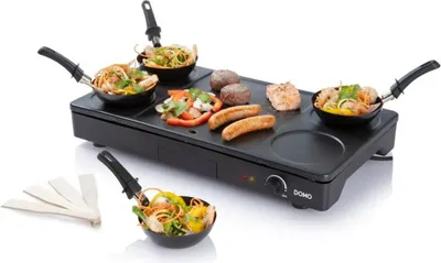 A raclette grill with food items on it and small pans.
