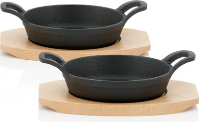 Two cast iron serving pans with wooden bases are shown against a white background.