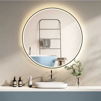 A modern bathroom vanity with a round illuminated mirror, sink, and faucet.