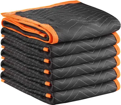 A stack of folded moving blankets with orange trim.