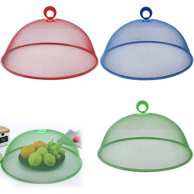 Four food covers in different colors, one of which is shown covering a plate of fruit.