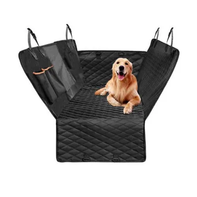 A golden retriever dog is lying on a black quilted car seat cover.