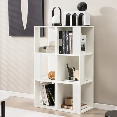A white cube bookshelf filled with books and decorative items, placed against a light gray wall.