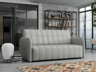 A modern living room with a sofa, bookshelf, and lamp.