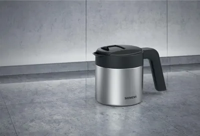 A Siemens coffee pot sits on a tiled countertop against a tiled wall.