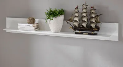A white shelf mounted on a light gray wall, displaying decorative items.