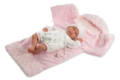 A baby doll lying on a pink blanket with a matching hood.