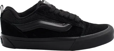 A side view of a black Vans sneaker against a white background.
