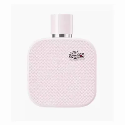 A pink Lacoste perfume bottle with a white cap and a silver band around the neck.