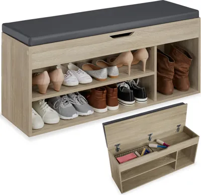 A shoe bench with storage and a cushioned top, shown with shoes on the shelves and the storage compartment open.