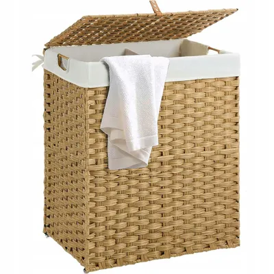 A woven laundry basket with a lid and a white towel draped over the side.